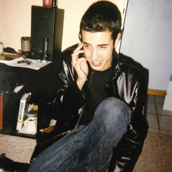 Cheyne in the 1990s, in a leather jacket, laughing on the phone